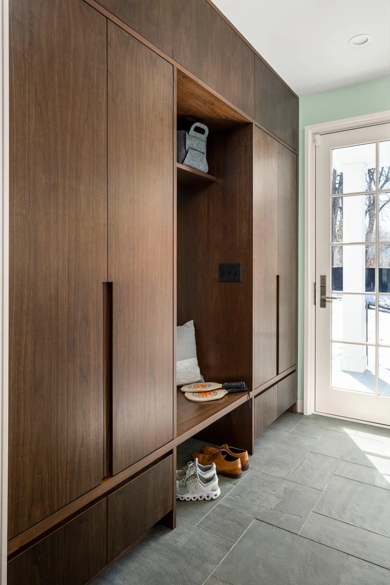 Crafting the Perfect Mudroom for Winter 2 In our Spanish Colonial project, custom walnut cabinetry concealed ample storage while maintaining a sleek, polished look.