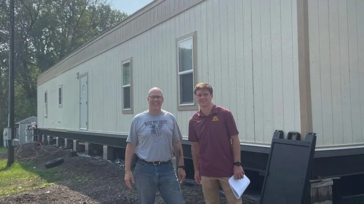 Two people in front of mobile home